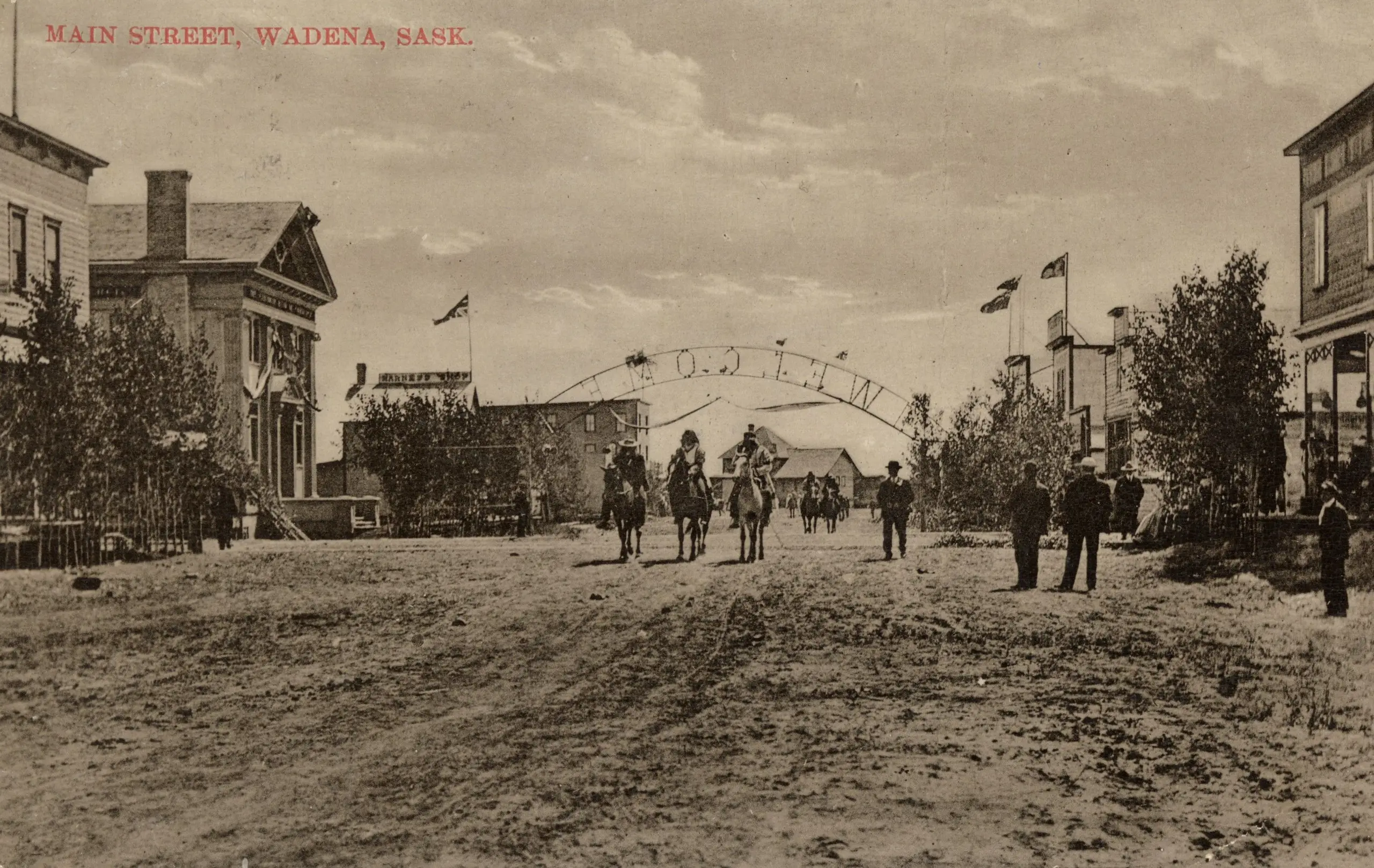 Main Street, Wadena, with welcome arch and riders on horseback